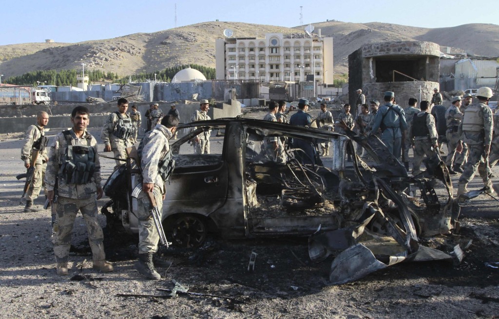 Afghan security forces inspect a damaged car, which was used during a suicide bomb attack, outside the U.S. consulate in Herat province September 13, 2013. At least three people were killed when insurgents attacked the U.S. consulate in Herat on Friday, detonating a powerful truck bomb outside the front gates and launching a gunbattle with security forces, officials said. REUTERS/Mohammad Shoib (AFGHANISTAN - Tags: CIVIL UNREST MILITARY POLITICS TPX IMAGES OF THE DAY)