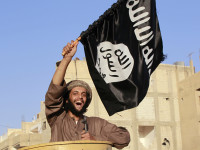 A militant Islamist fighter waving a flag, cheers as he takes part in a military parade along the streets of Syria's northern Raqqa province June 30, 2014. The fighters held the parade to celebrate their declaration of an Islamic "caliphate" after the group captured territory in neighbouring Iraq, a monitoring service said. The Islamic State, an al Qaeda offshoot previously known as Islamic State in Iraq and the Levant (ISIL), posted pictures online on Sunday of people waving black flags from cars and holding guns in the air, the SITE monitoring service said. Picture taken June 30, 2014.  REUTERS/Stringer (SYRIA - Tags: POLITICS CIVIL UNREST CONFLICT) - RTR3WKMT