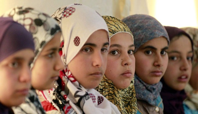 Syrian refugee girls sit at the United Nations Children's Fund (UNICEF) "Child Friendly Spaces" (CFSs) in the Zaatari refugee camp, near the Jordanian border with Syria, on March 8, 2014.