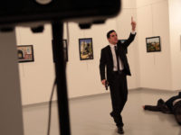 A man gestures near to Andrei Karlov on ground,  the Russian Ambassador to Turkey at a photo gallery in Ankara, Turkey, Monday, Dec. 19, 2016. An Associated Press photographer says a gunman has fired shots at the Russian ambassador to Turkey. The ambassador's condition wasn't immediately known. (AP Photo/Burhan Ozbilici)