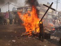 A demonstrator burns a cross during a protest in the Badami Bagh area of Lahore March 9, 2013. An enraged mob torched dozens of houses located in a Christian-dominated neighbourhood of Lahore on Saturday, local media reported. REUTERS/Adrees Hassain