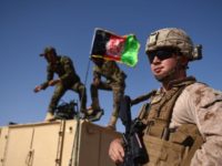 In this photograph taken on August 28, 2017, a US Marine looks on as Afghan National Army soldiers raise the Afghan National flag on an armed vehicle during a training exercise to deal with IEDs (improvised explosive devices) at the Shorab Military Camp in Lashkar Gah in Helmand province.
Marines in Afghanistan's Helmand say Donald Trump's decision to keep boots on the ground indefinitely gives them "all the time in the world" to retake the province, once the symbol of US intervention but now a Taliban stronghold. They may need it. At the hot, dusty Camp Shorab, where many of the recently deployed Marines train their Afghan counterparts in flat, desert terrain, the Afghans admit their army still cannot fight alone.

 / AFP PHOTO / WAKIL KOHSAR        (Photo credit should read WAKIL KOHSAR/AFP via Getty Images)